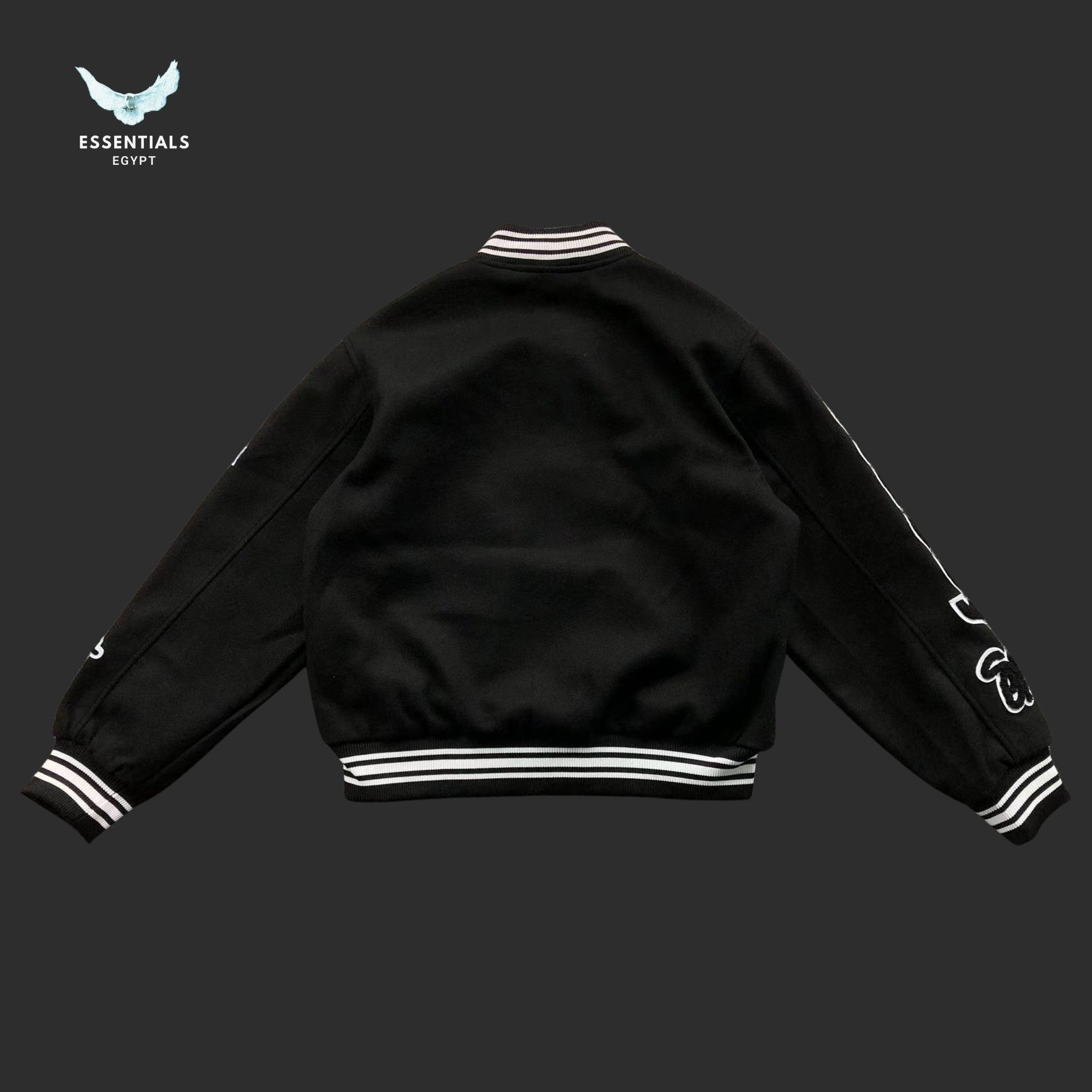 Black Stussy varsity jacket with bold white logo graphics on both sleeves